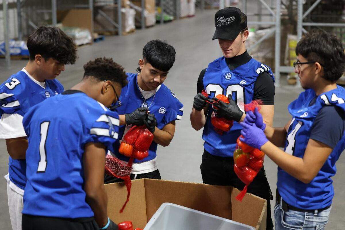 The Sanger West football players pack bell peppers at the Central California Food Bank.